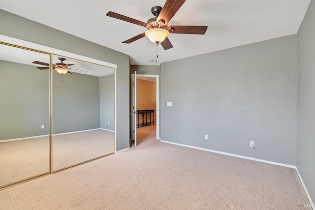 unfurnished bedroom with baseboards, carpet, a closet, and ceiling fan