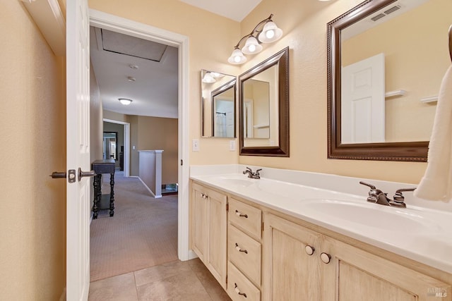 bathroom featuring tile patterned floors, visible vents, a sink, and double vanity