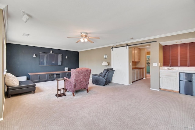 living room with a barn door, crown molding, light colored carpet, and ceiling fan