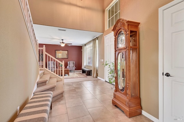 entrance foyer featuring stairway, visible vents, light tile patterned floors, baseboards, and ceiling fan