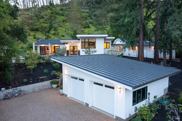modern home with a garage, a standing seam roof, and metal roof