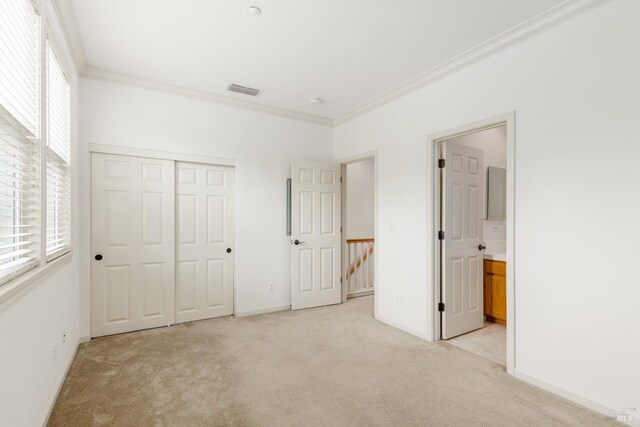 unfurnished bedroom with light carpet, visible vents, a closet, and ornamental molding