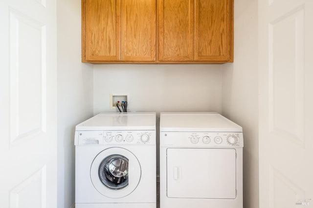 washroom with washing machine and dryer and cabinet space