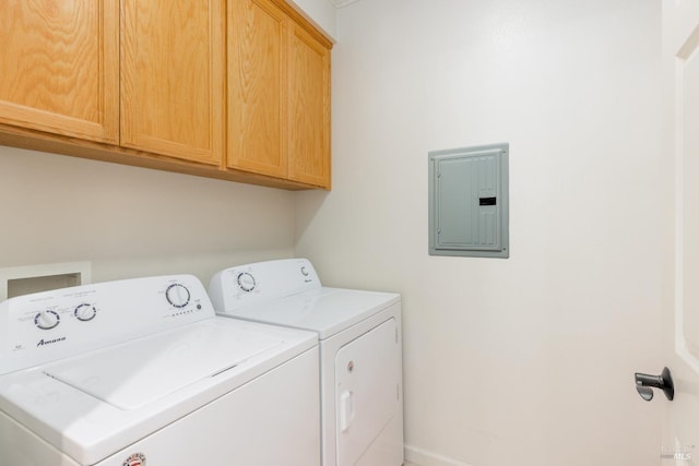 laundry room with washing machine and dryer, electric panel, baseboards, and cabinet space