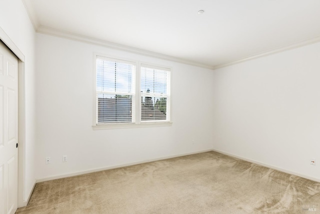 unfurnished bedroom with light carpet, baseboards, a closet, and ornamental molding