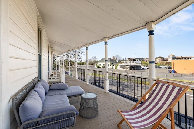 wooden deck featuring covered porch and a residential view
