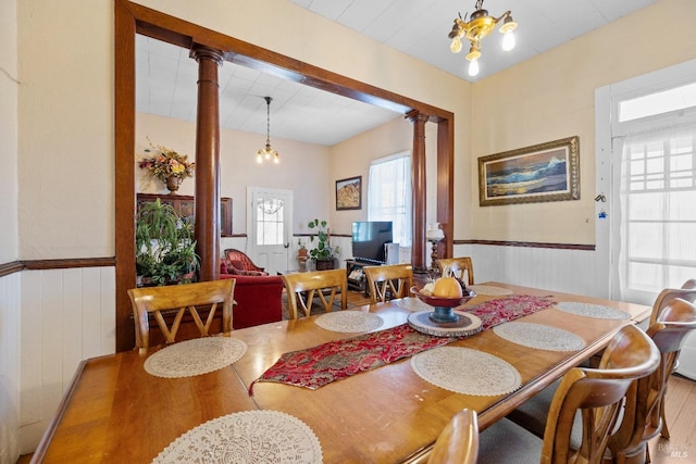 dining room with a wainscoted wall and ornate columns