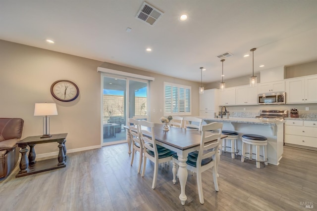 dining area with baseboards, recessed lighting, wood finished floors, and visible vents