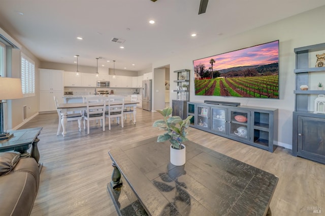 living area featuring recessed lighting, baseboards, visible vents, and light wood-type flooring