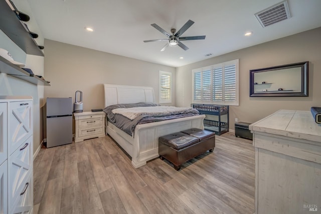 bedroom featuring visible vents, freestanding refrigerator, light wood finished floors, and recessed lighting