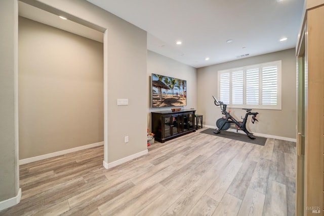 workout area with recessed lighting, baseboards, and light wood-type flooring