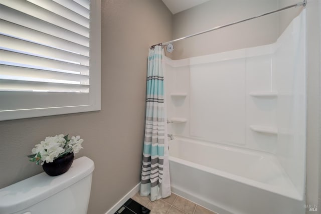full bathroom with baseboards, tile patterned flooring, shower / bath combo, and toilet