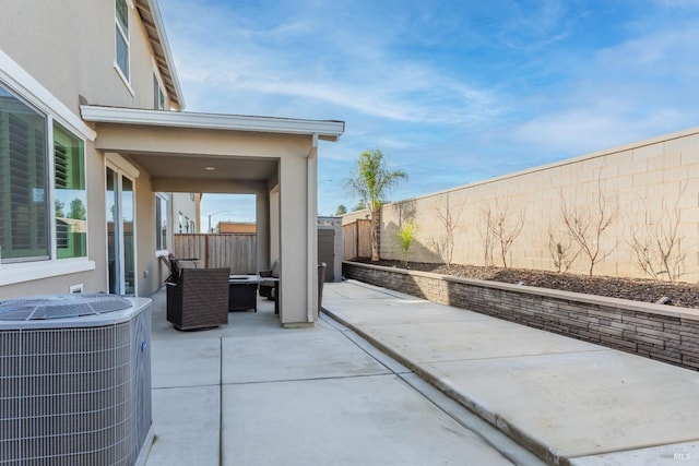 view of patio featuring central air condition unit, an outdoor living space, and a fenced backyard