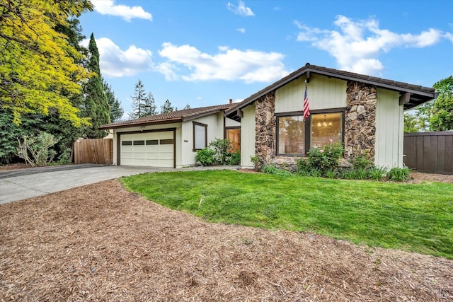 mid-century home with stone siding, a garage, fence, concrete driveway, and a front yard