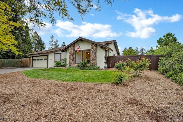 mid-century home with a front yard, fence, an attached garage, and driveway