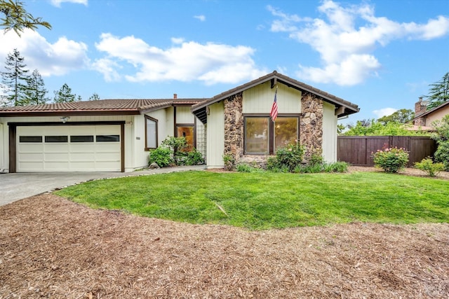 view of front of home with concrete driveway, a front yard, an attached garage, and fence