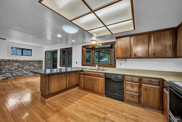 kitchen featuring a peninsula, light wood-style flooring, a sink, black dishwasher, and range with electric stovetop
