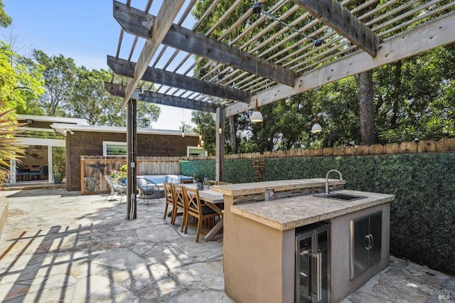 view of patio with outdoor dry bar, area for grilling, exterior kitchen, a pergola, and a fenced backyard
