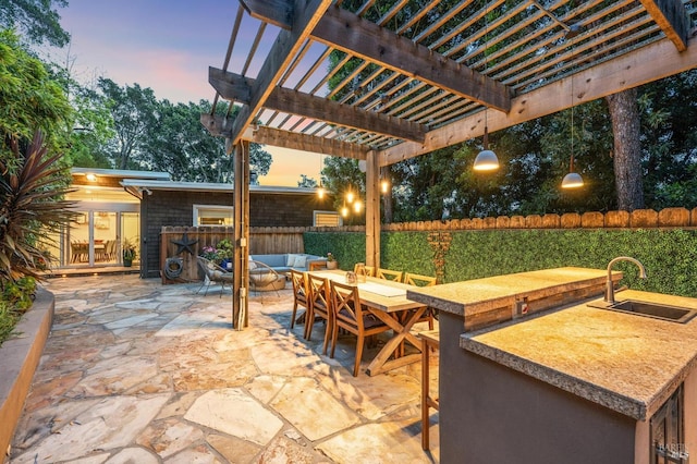 patio terrace at dusk with an outdoor living space, a pergola, outdoor dry bar, and a sink