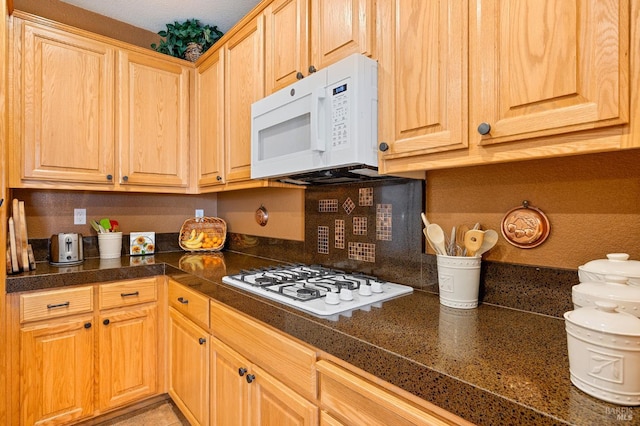 kitchen with light brown cabinetry, backsplash, tile countertops, and white appliances