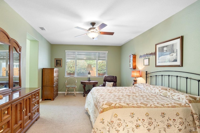 bedroom featuring visible vents, a ceiling fan, baseboards, and light carpet