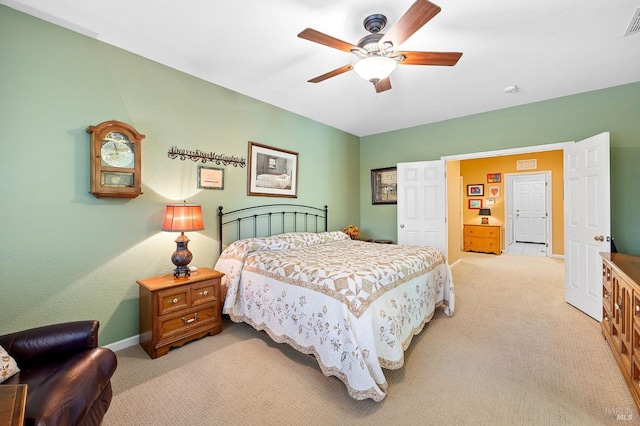 bedroom with baseboards, a ceiling fan, visible vents, and light carpet