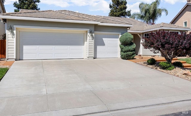 ranch-style home with concrete driveway, an attached garage, and a tile roof