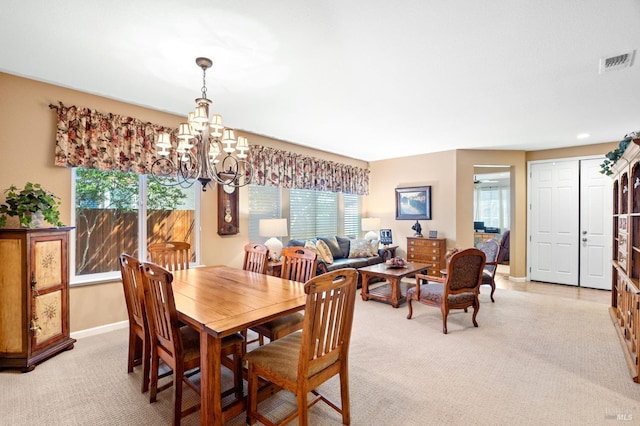 dining area with visible vents, a notable chandelier, a wealth of natural light, and light colored carpet
