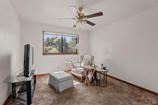 living area with a ceiling fan, baseboards, and carpet