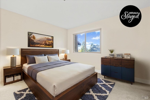 bedroom with baseboards and light colored carpet