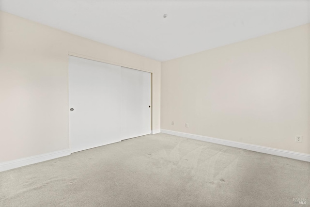 empty room featuring carpet floors and baseboards