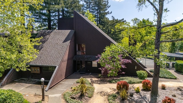 view of front of home featuring fence and roof with shingles