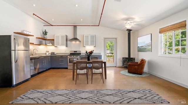 3880 Doris Murphy Ct, Occidental, CA 95465 - kitchen with stainless steel appliances, wall chimney range hood, a wood stove, open shelves, and ceiling fan