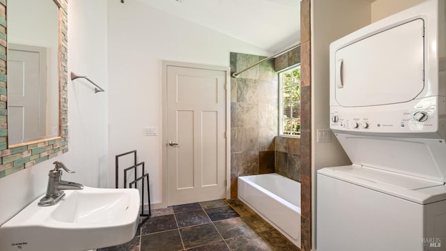 3880 Doris Murphy Ct, Occidental, CA 95465 - full bathroom featuring stacked washer / drying machine, a sink, lofted ceiling, washtub / shower combination, and stone finish flooring