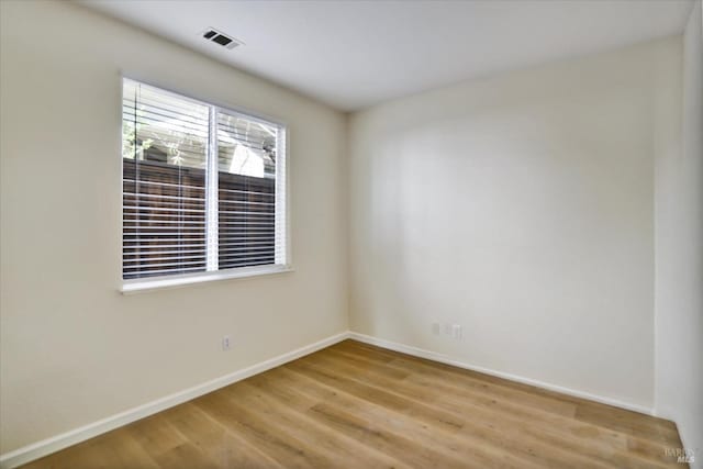 empty room with baseboards, visible vents, and light wood-style flooring