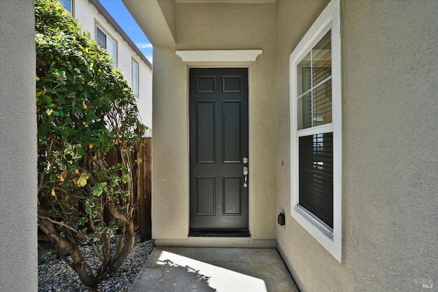 doorway to property featuring stucco siding