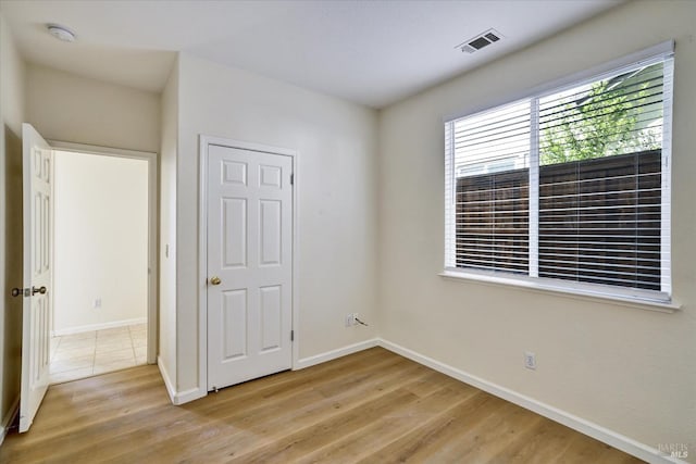 unfurnished bedroom with baseboards, light wood-style flooring, and visible vents