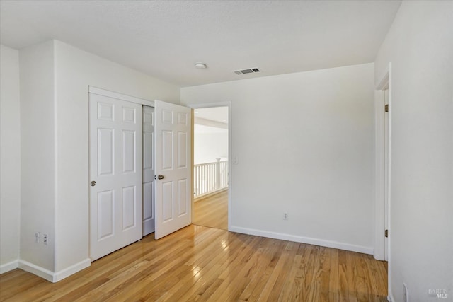 unfurnished bedroom featuring baseboards, visible vents, and light wood-type flooring