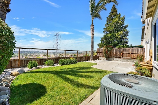 view of yard with a fenced backyard, central AC, and a patio