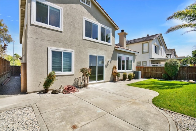 back of property with cooling unit, a yard, a fenced backyard, and stucco siding
