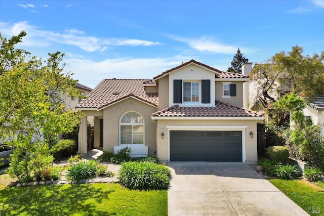 mediterranean / spanish home featuring a chimney, a tiled roof, stucco siding, an attached garage, and driveway