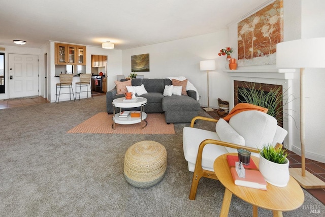 living area with a tile fireplace and carpet