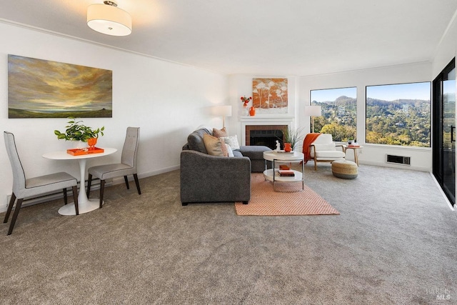 living area with carpet, baseboards, visible vents, and a fireplace
