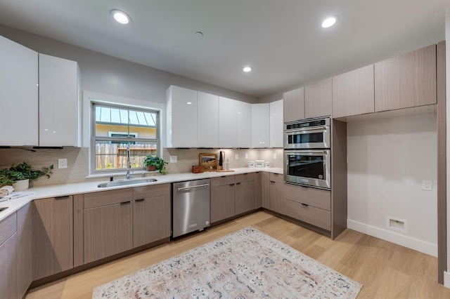 kitchen with light wood-style floors, tasteful backsplash, appliances with stainless steel finishes, and modern cabinets