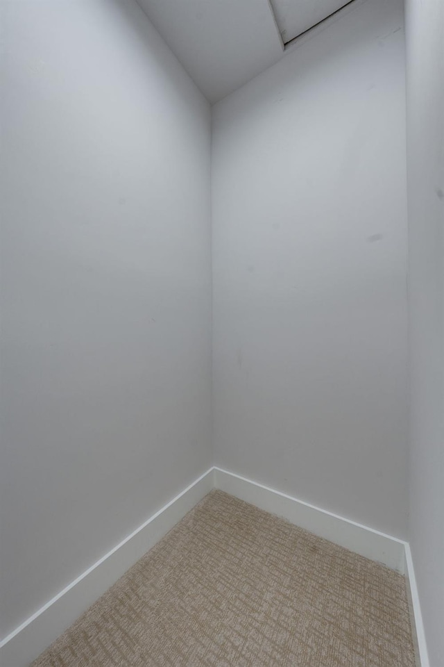 carpeted empty room featuring baseboards