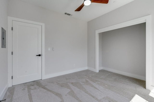 interior space featuring electric panel, baseboards, visible vents, carpet, and ceiling fan
