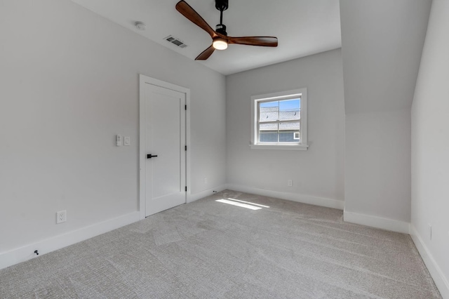 empty room featuring carpet floors, visible vents, baseboards, and ceiling fan