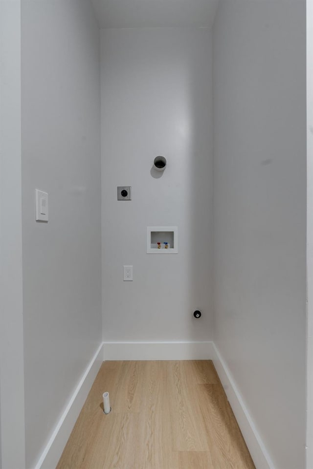clothes washing area featuring baseboards, light wood-style floors, hookup for a washing machine, electric dryer hookup, and laundry area