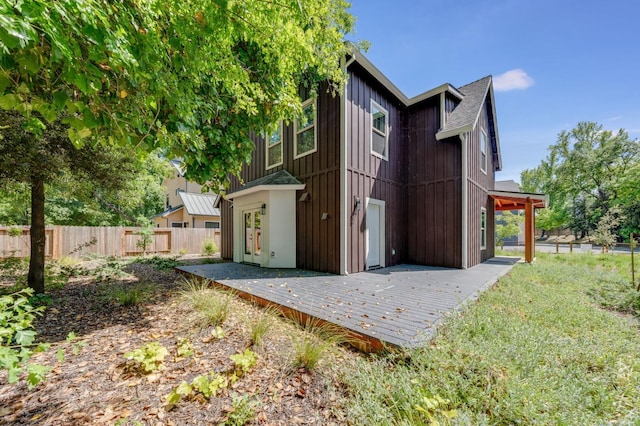 view of side of home featuring a wooden deck and fence