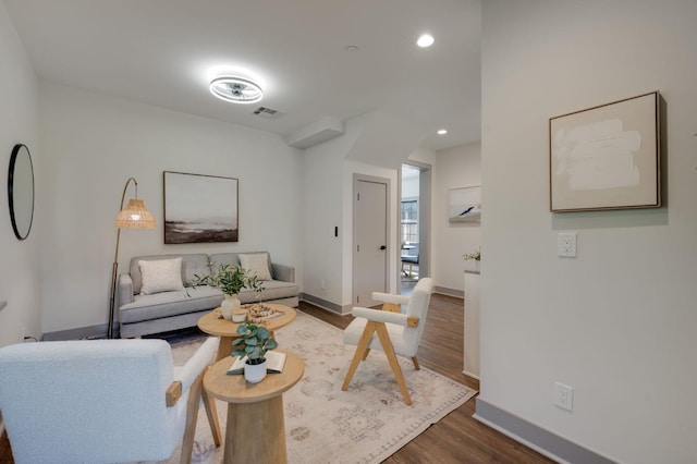living area featuring baseboards, dark wood-type flooring, visible vents, and recessed lighting